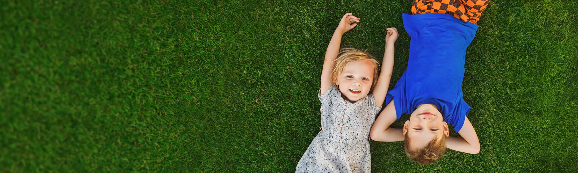 Happy kids looking up on green grasses